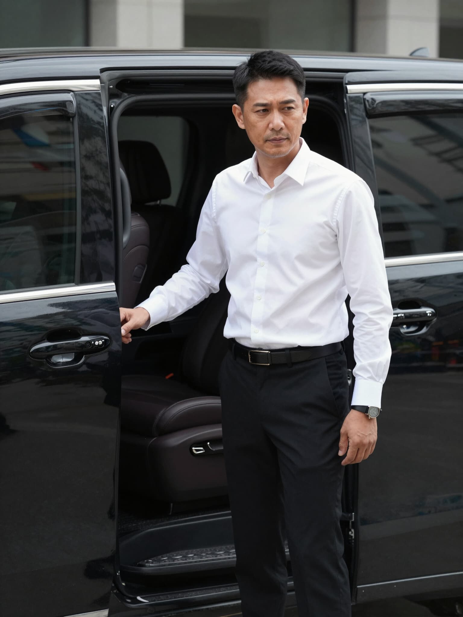 Chauffeur opening the sliding door of a mödl van